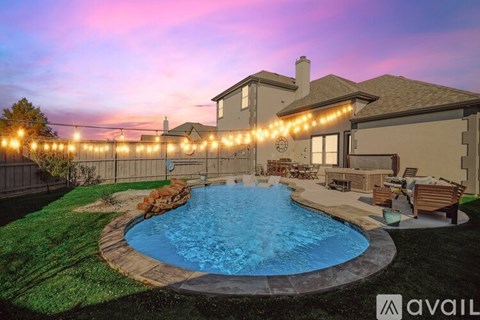 A house with a pool and lights around it.