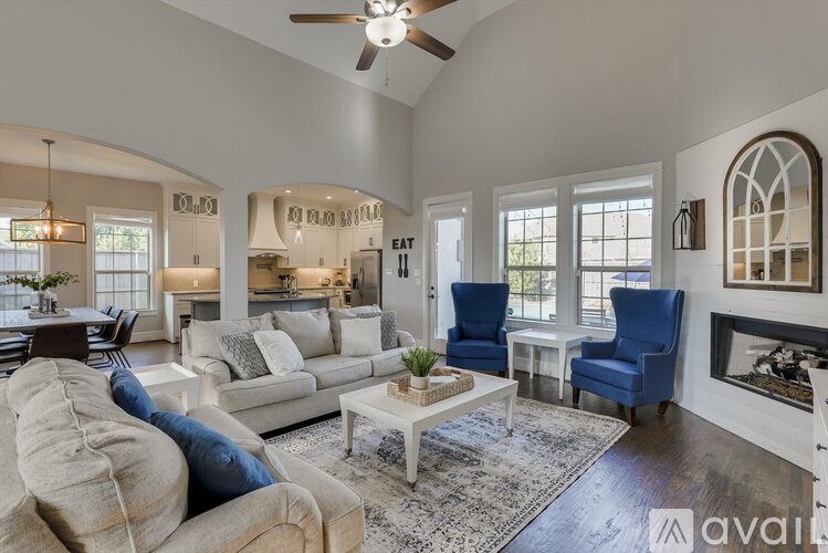 A living room with a white couch and blue chairs.