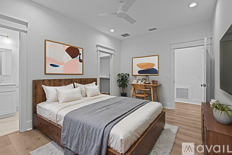 A bedroom with a large bed and a ceiling fan.