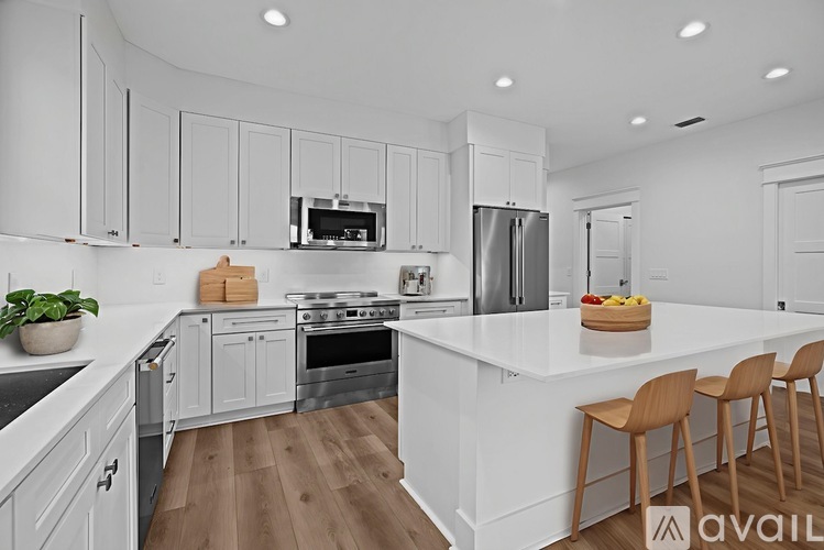 A modern kitchen with white cabinets and a wooden island.