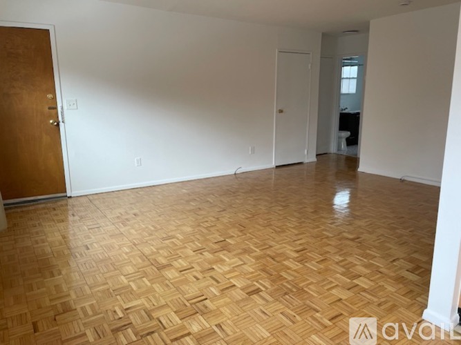A room with wooden flooring and white walls.