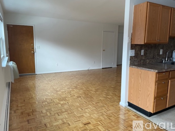 A kitchen with wooden cabinets and a tiled floor.