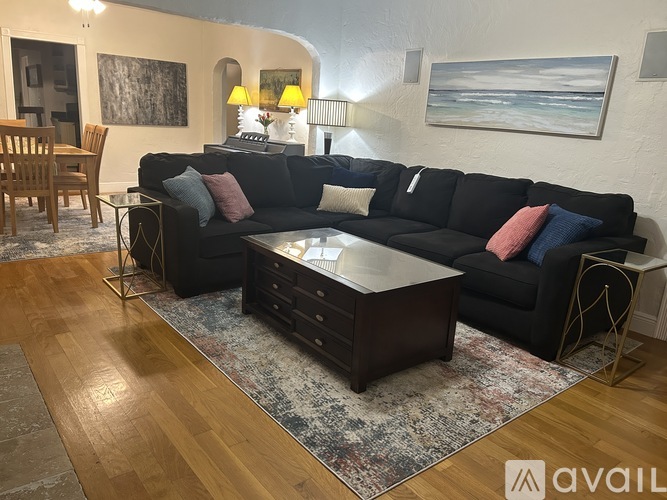A living room with a black couch and a coffee table.