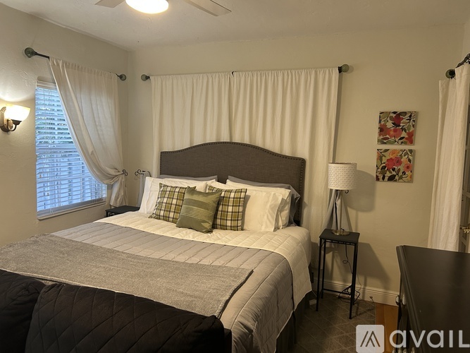 A bedroom with a large bed and a ceiling fan.
