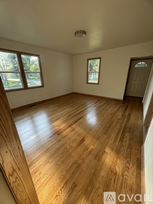 A room with wooden flooring and a window.