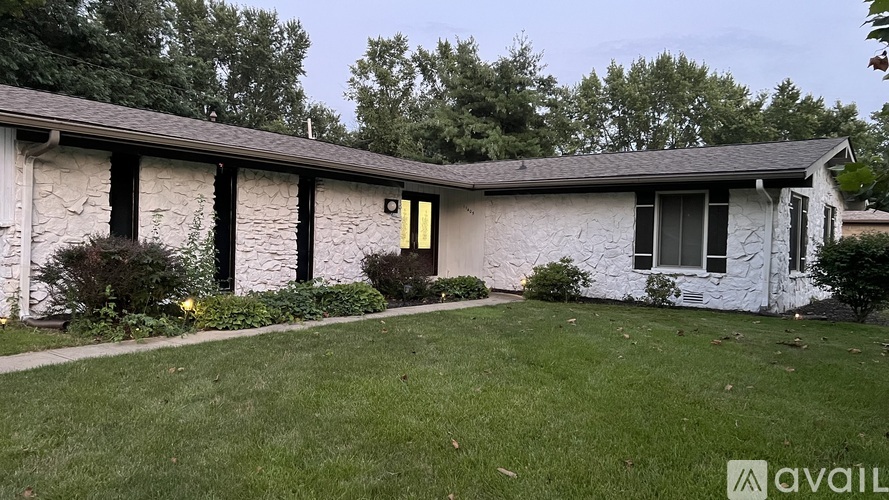 A house with a white exterior and a yellow door is for sale.