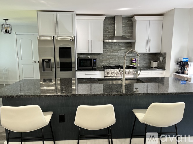 A kitchen with a granite countertop and white cabinets.