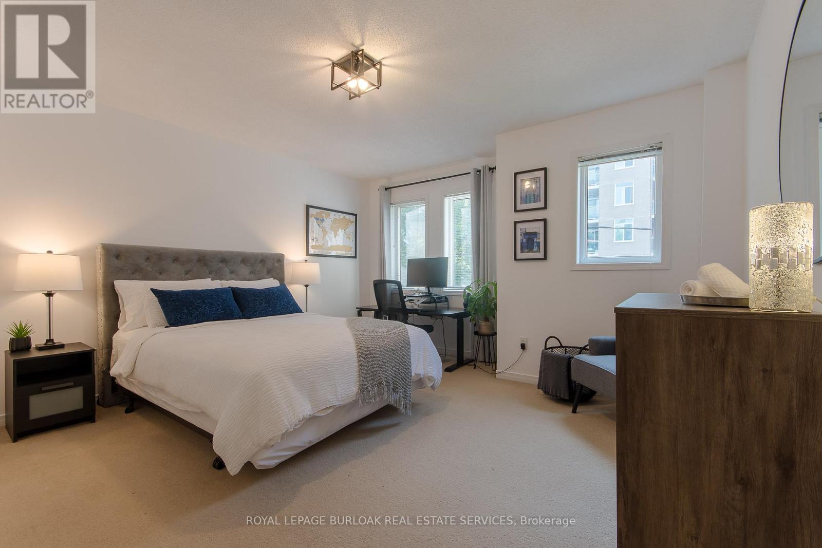 A bedroom with a large bed and a desk with a chair.