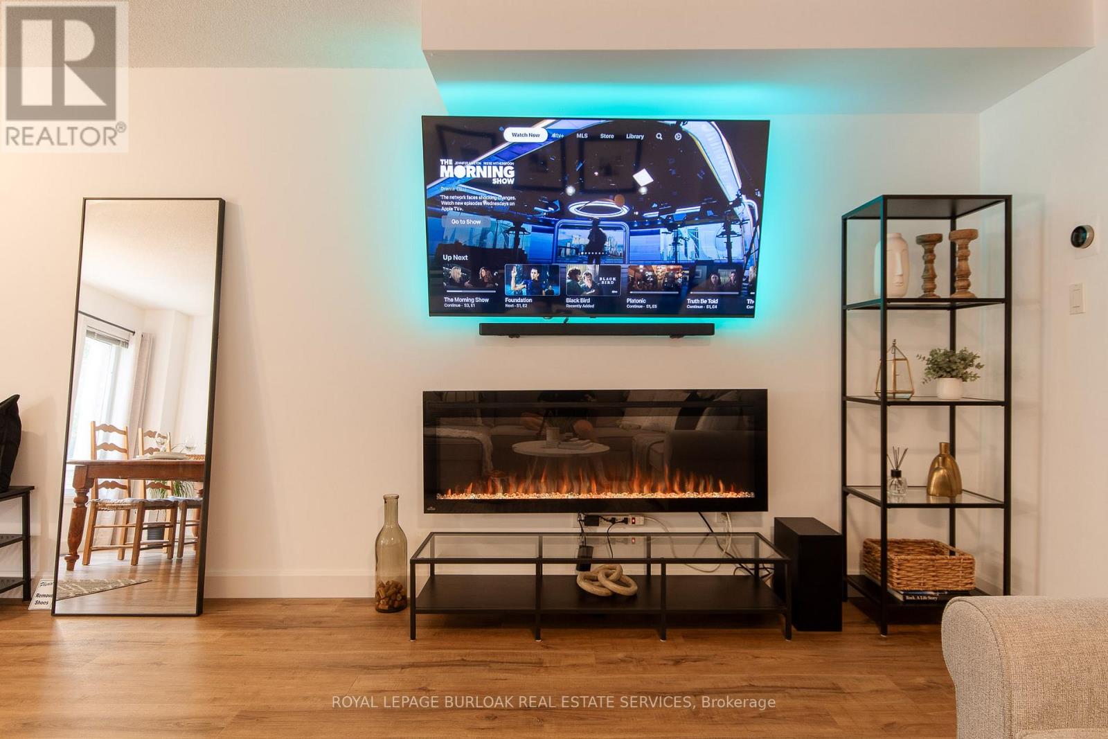 A modern living room with a flat screen TV mounted on the wall.
