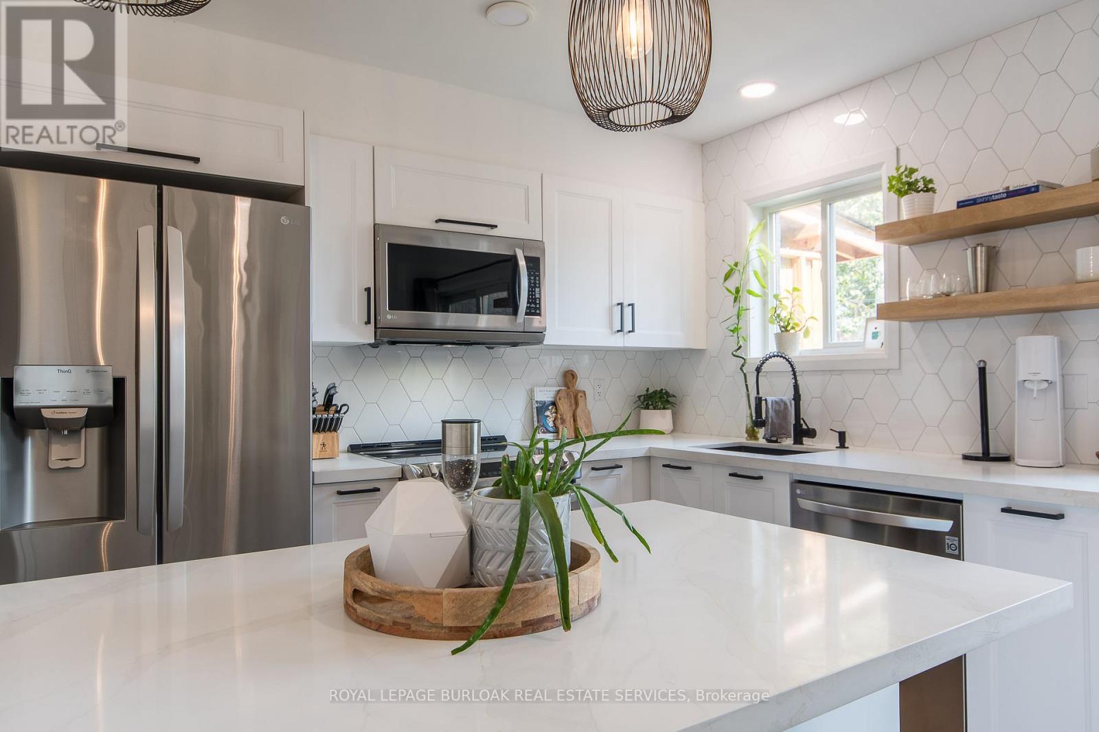 A kitchen with a white counter top and a refrigerator.