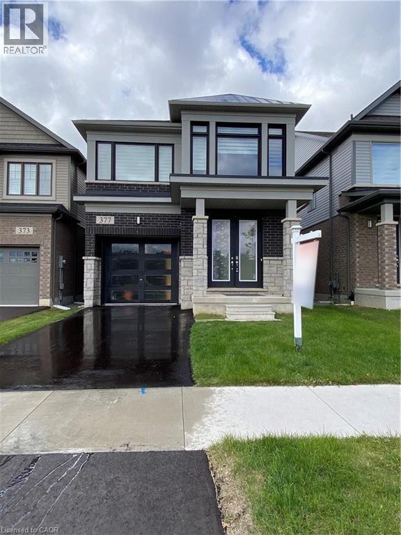 A modern house with a glass door and a wet driveway.