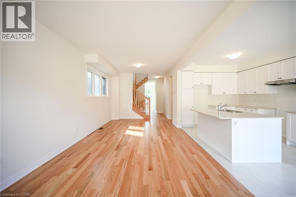 A spacious room with wooden flooring and white walls.