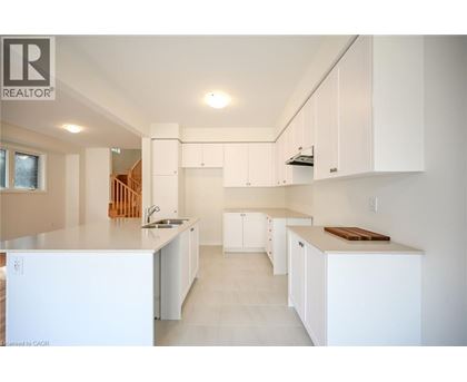 A white kitchen with a sink and cabinets.