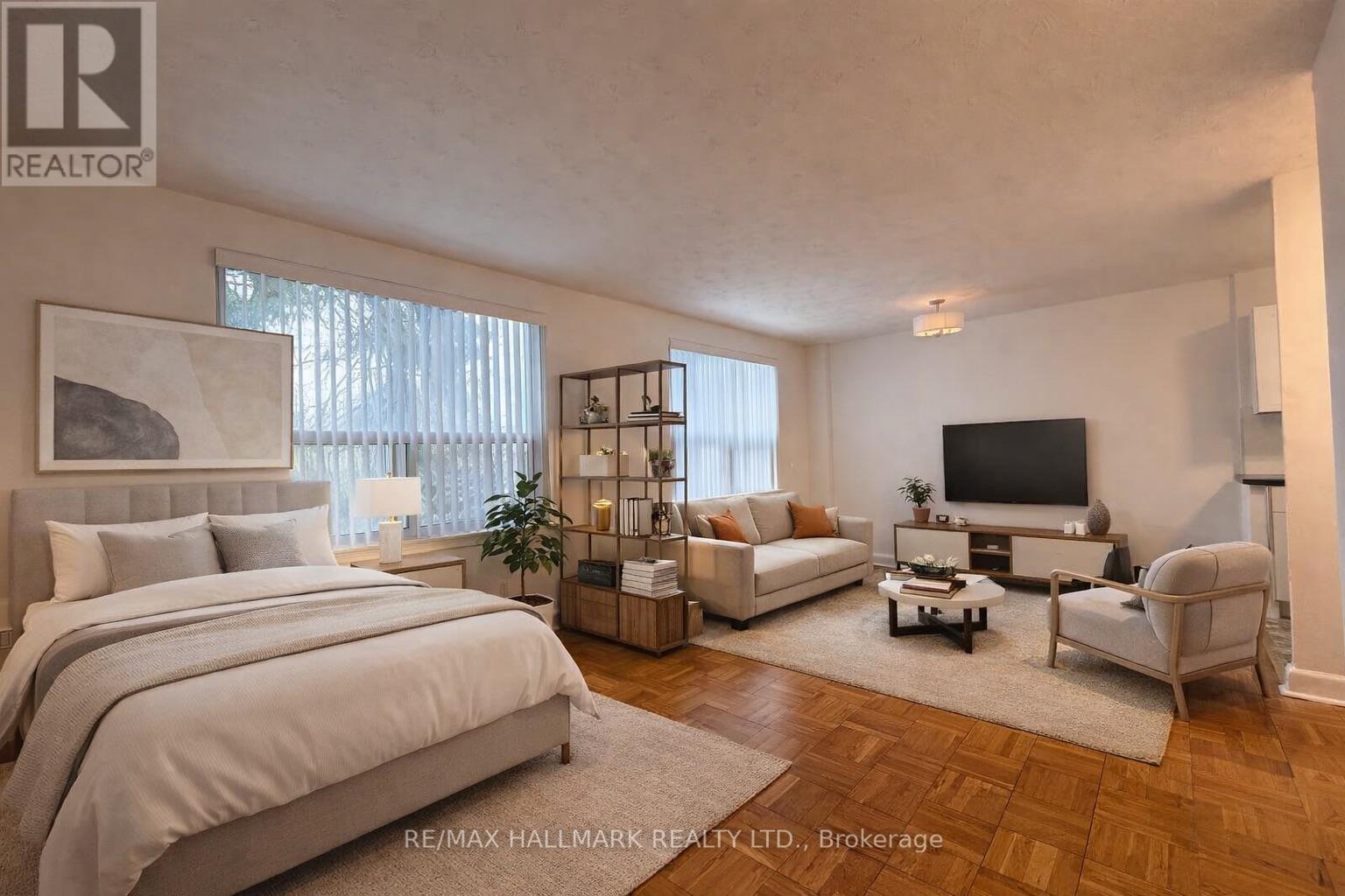 A room with wooden flooring and a window with blinds.