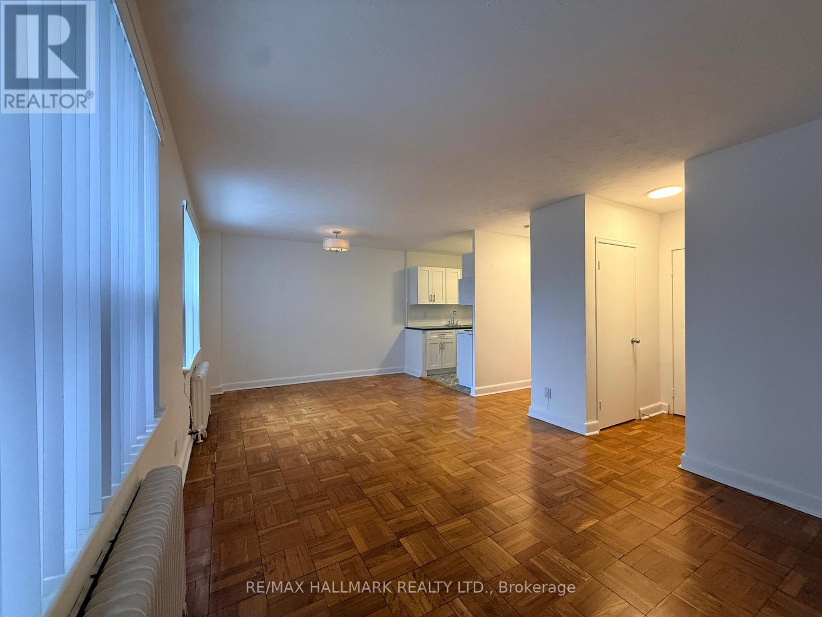 A room with wooden flooring and white walls.