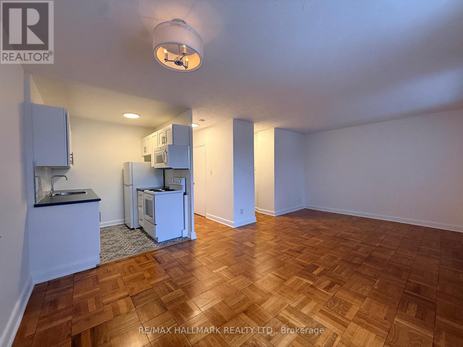 A kitchen area with a sink and a refrigerator.