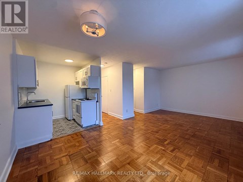 A kitchen area with a sink and a refrigerator.