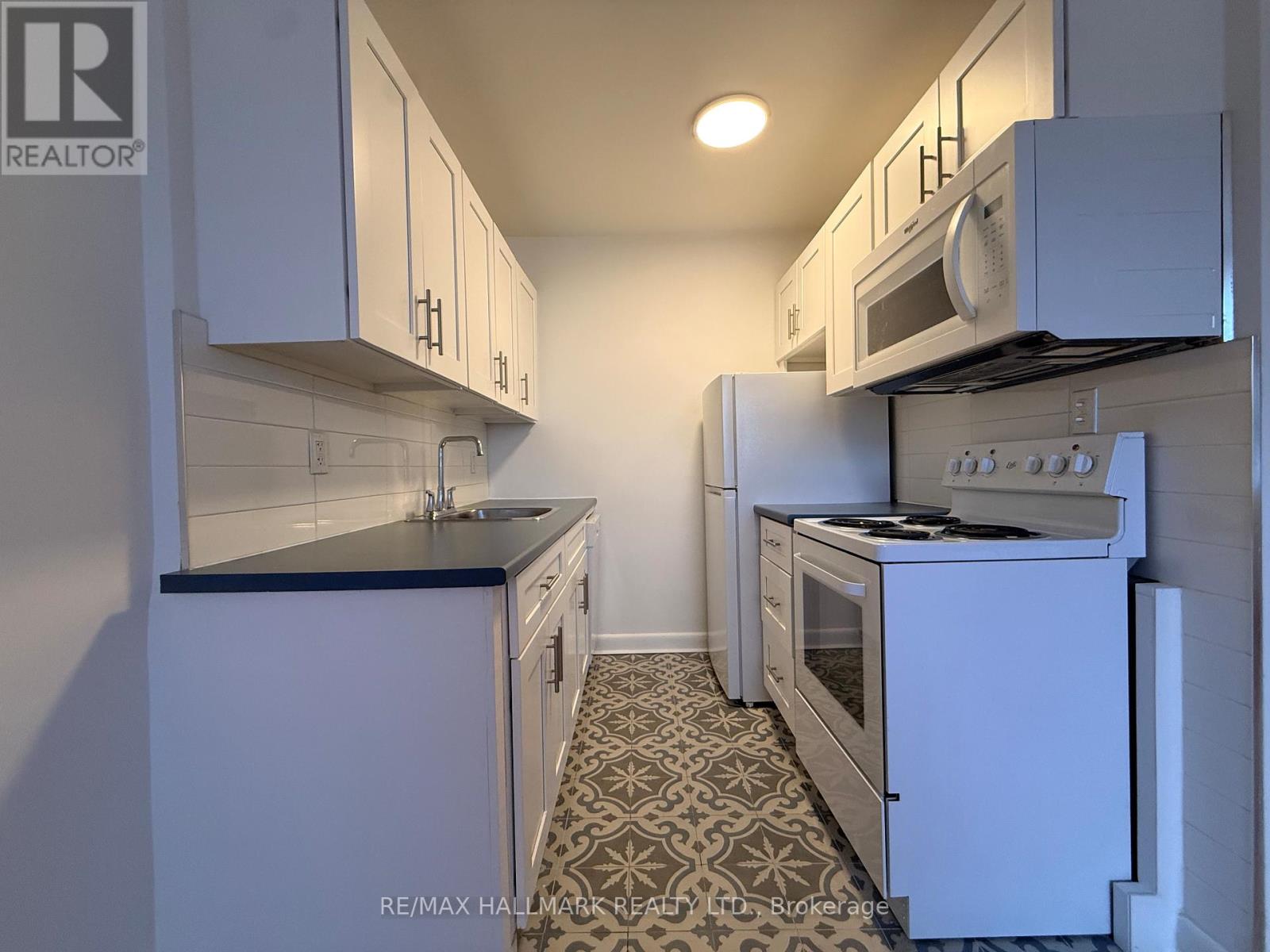 A kitchen with white cabinets and appliances.