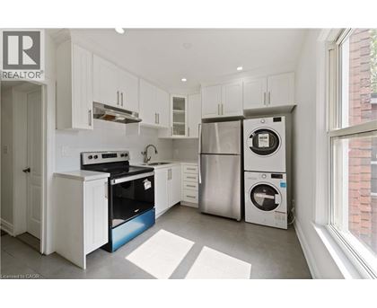 A modern kitchen with white cabinets and stainless steel appliances.