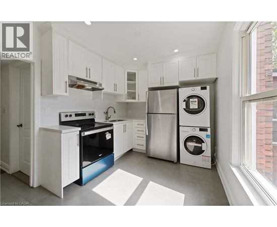 A modern kitchen with white cabinets and stainless steel appliances.