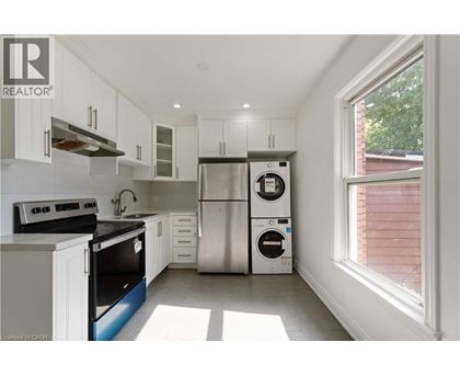 A kitchen with white cabinets and a stainless steel refrigerator.
