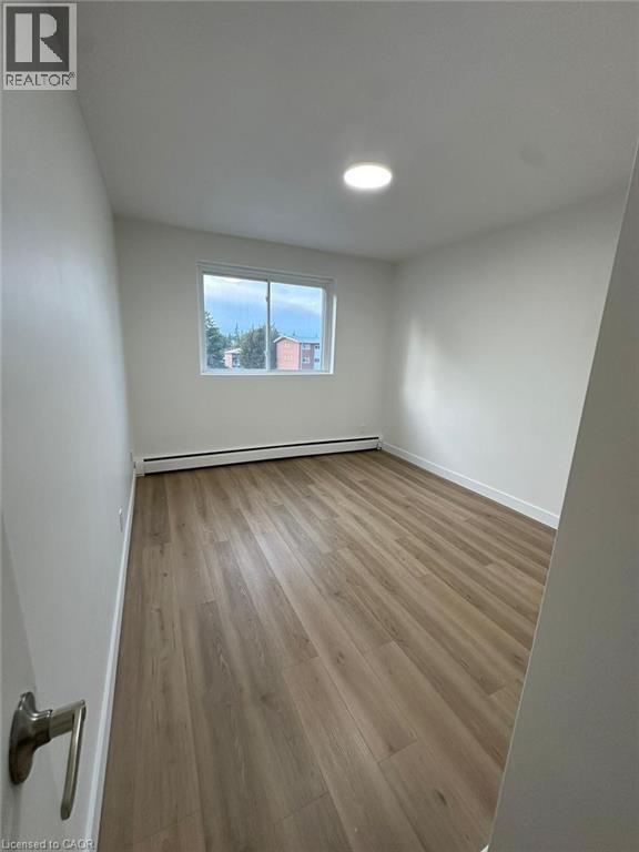 A room with a window and wooden flooring.