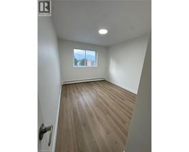 A room with a window and wooden flooring.