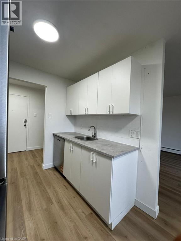 A kitchen with white cabinets and a sink.