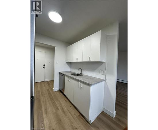 A kitchen with white cabinets and a sink.