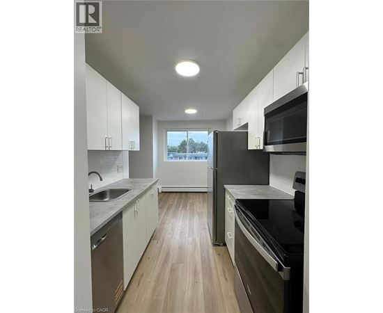 A modern kitchen with white cabinets and black appliances.
