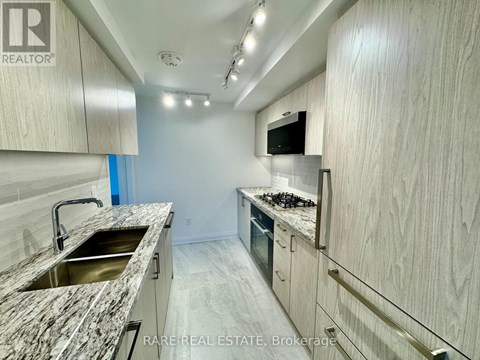 A kitchen with a granite countertop and stainless steel appliances.