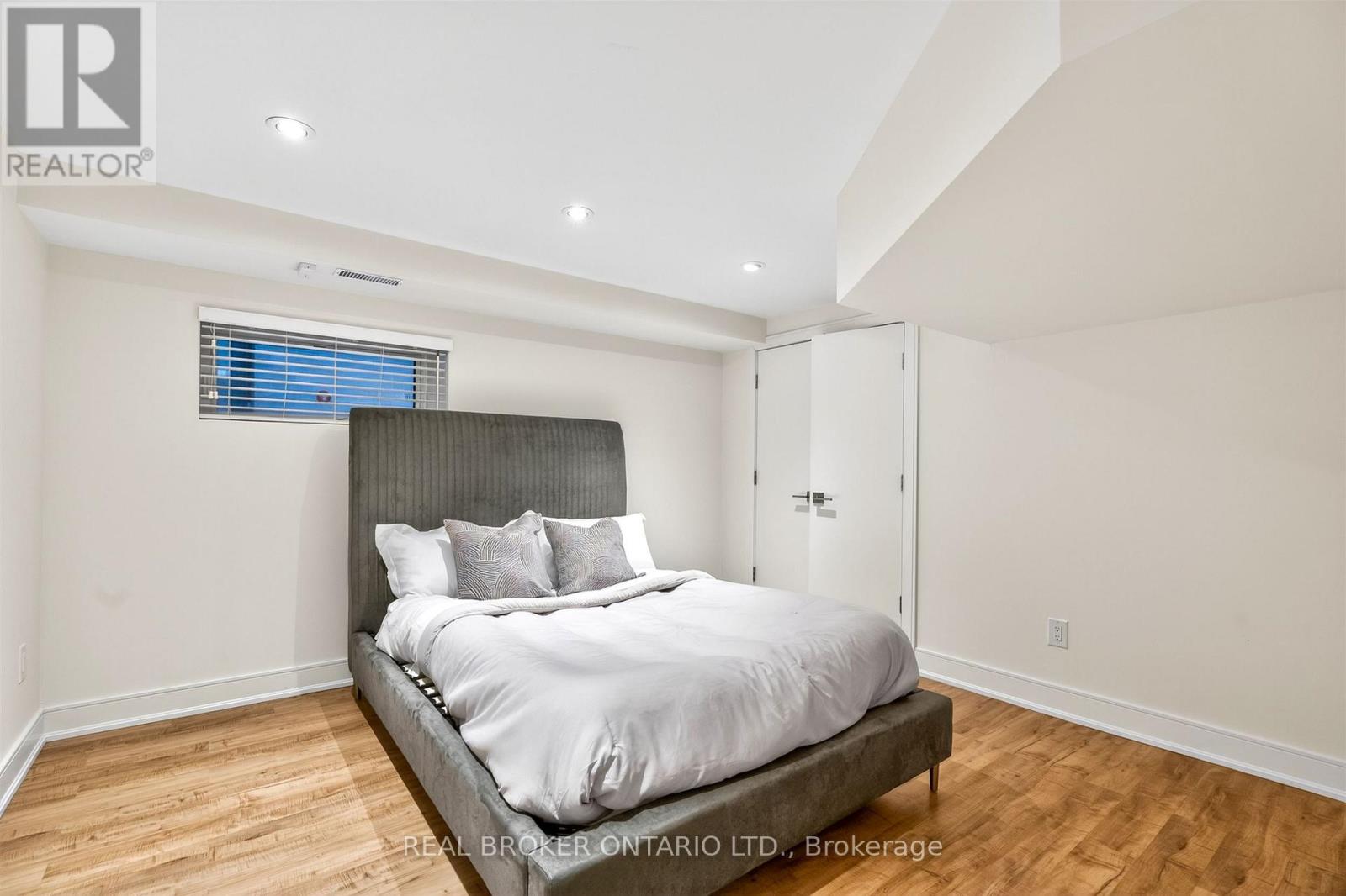 A bedroom with a large bed and wooden floors.