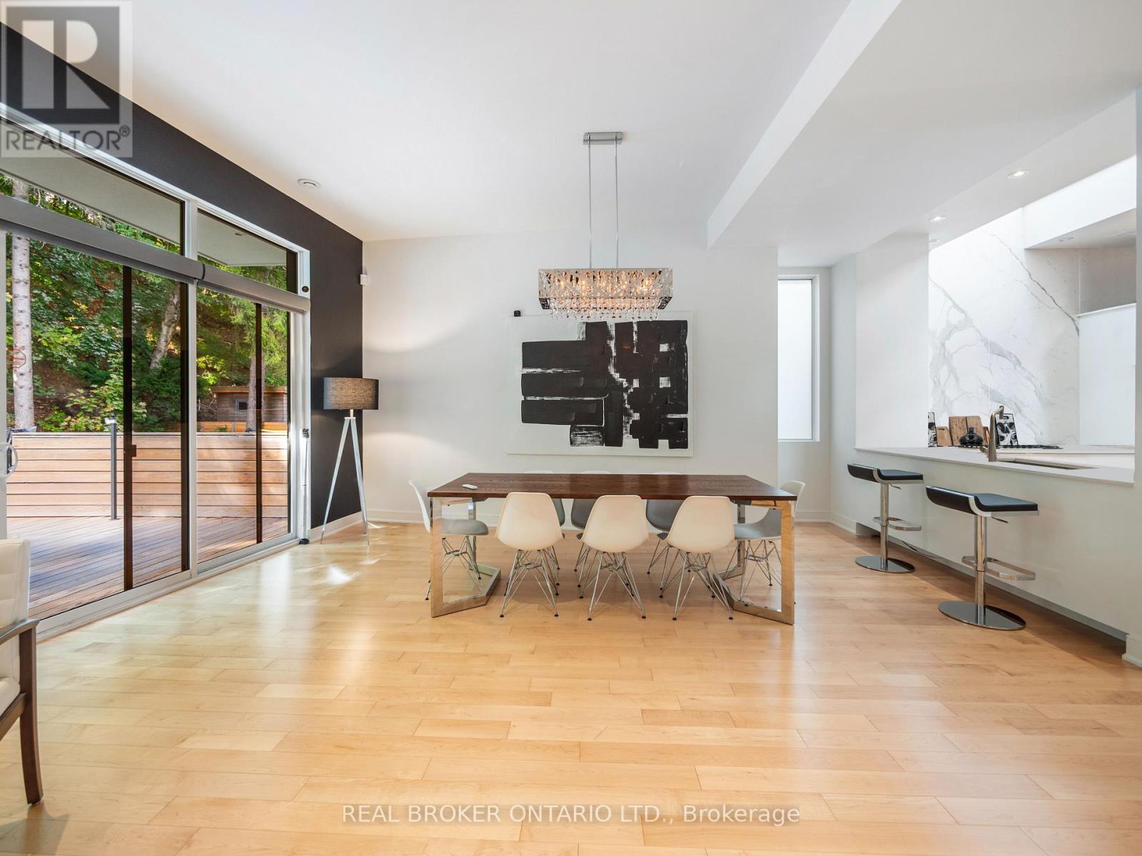 A modern dining room with a wooden table and chairs.