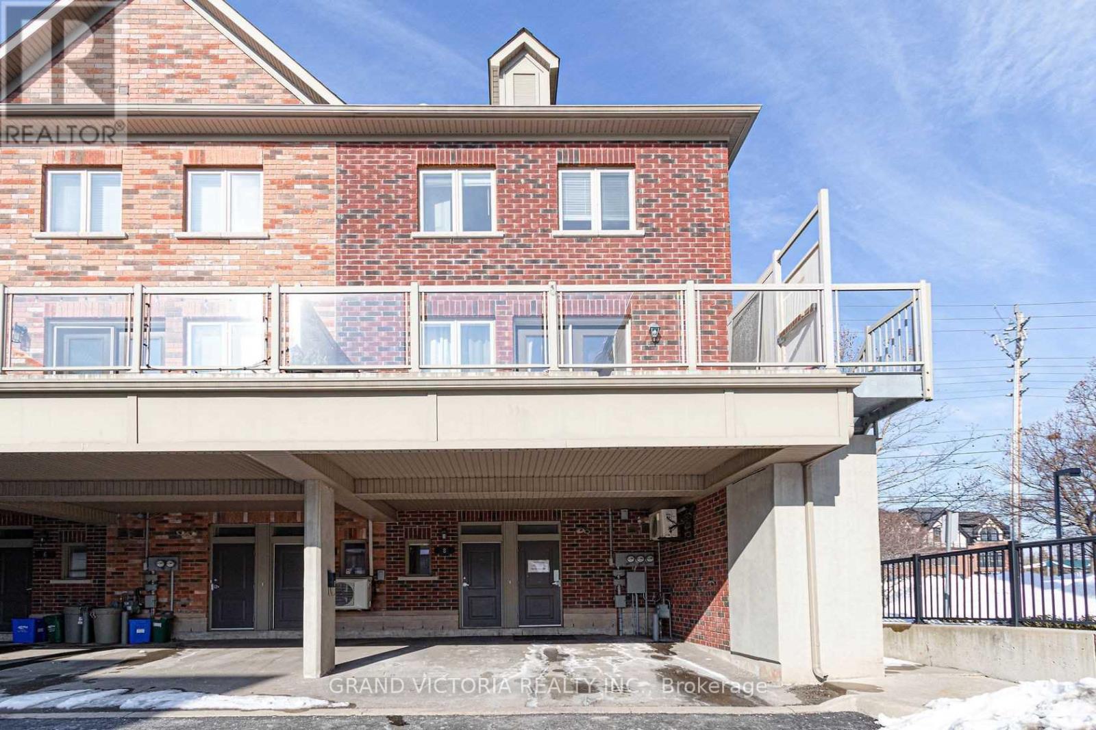 A red brick building with a white balcony in front.