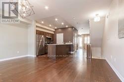 A spacious living room with a wooden floor and a large mirror on the wall.