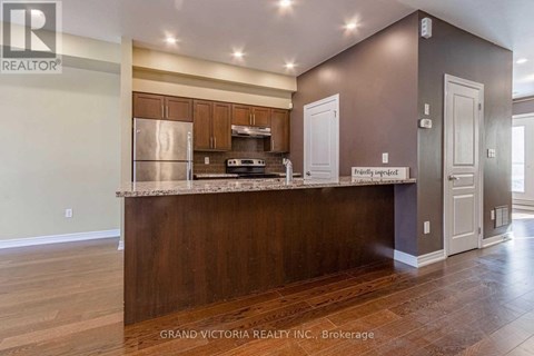 A kitchen with a brown counter top and a refrigerator.