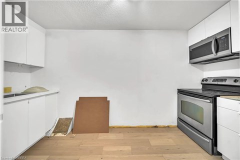 A kitchen with white cabinets and a black oven.