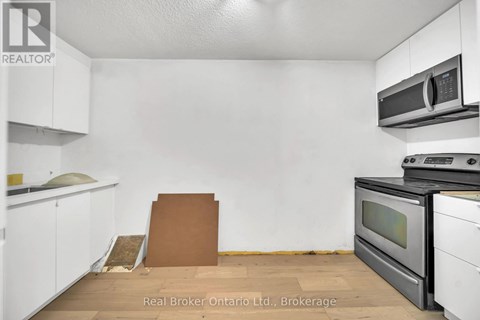 A kitchen with white cabinets and a black stove top oven.