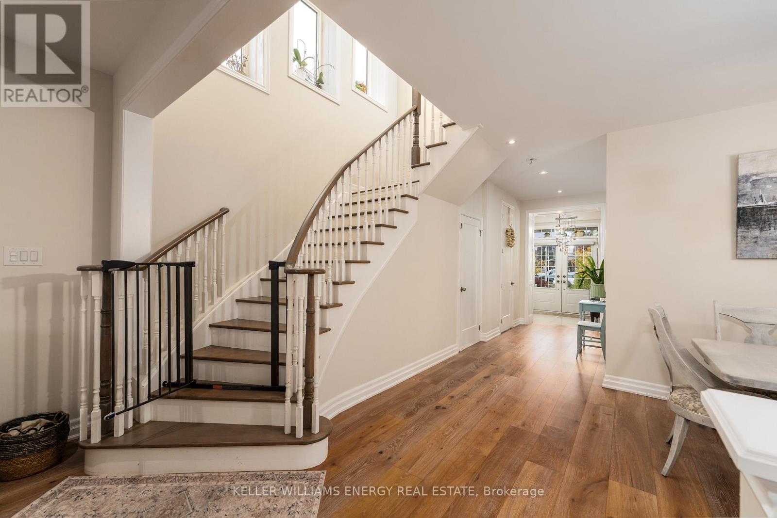 A spacious hallway with a staircase and a bench.