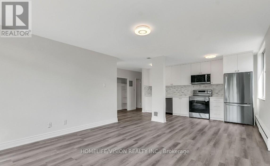 A spacious kitchen with white cabinets and stainless steel appliances.