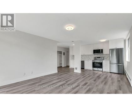 A spacious kitchen with white cabinets and stainless steel appliances.