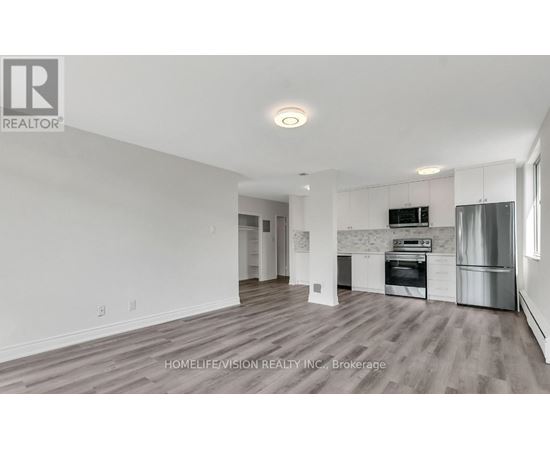 A spacious kitchen with white cabinets and stainless steel appliances.