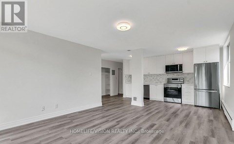 A spacious kitchen with white cabinets and stainless steel appliances.
