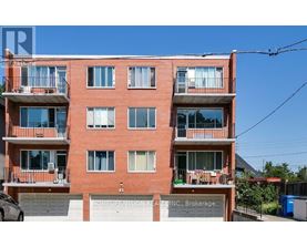 A red brick building with balconies and a sign that reads "HOMELIFE VISION REALTY INC., Brokerage".