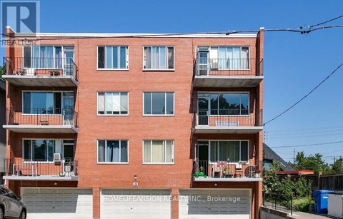 A red brick building with balconies and a sign that reads "HOMELIFE VISION REALTY INC., Brokerage".