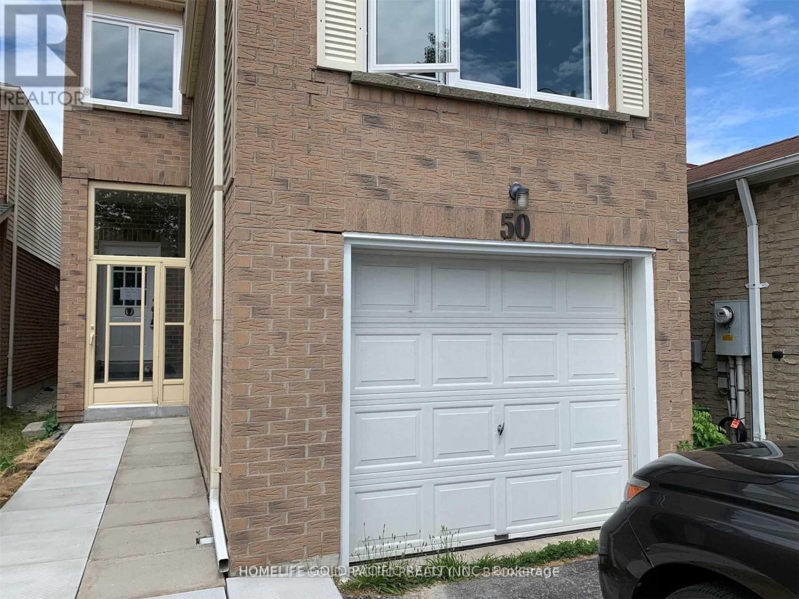 A brick building with a white garage door and number 50 on the brick.