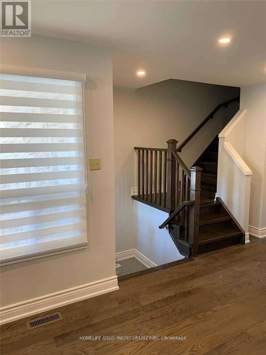 A wooden staircase with a white wall and a window with blinds.