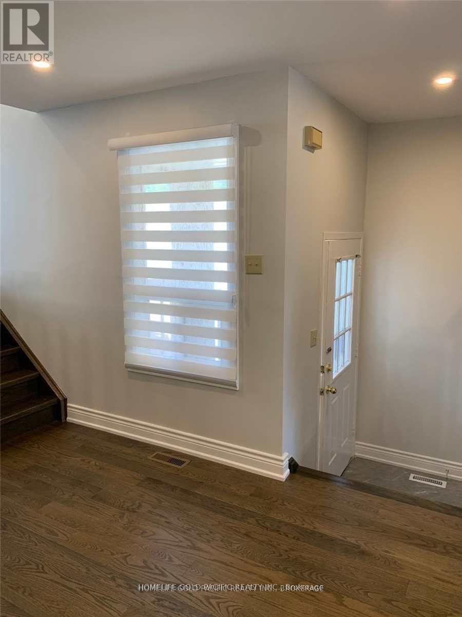 A room with a wooden floor and a white door.