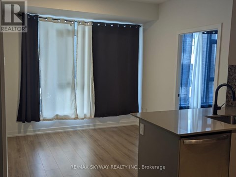 A kitchen with a sink and a window with curtains.