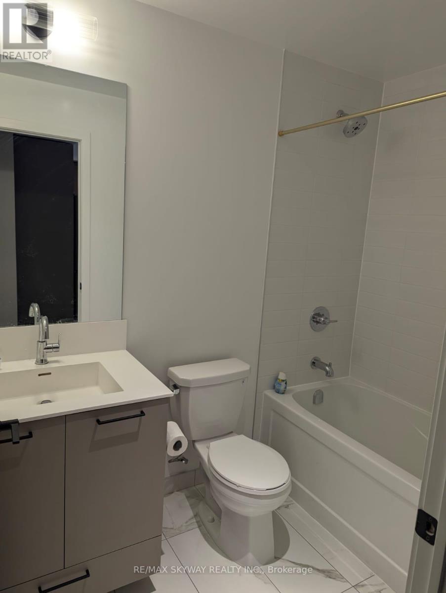 A white bathroom with a toilet, sink, and bathtub.